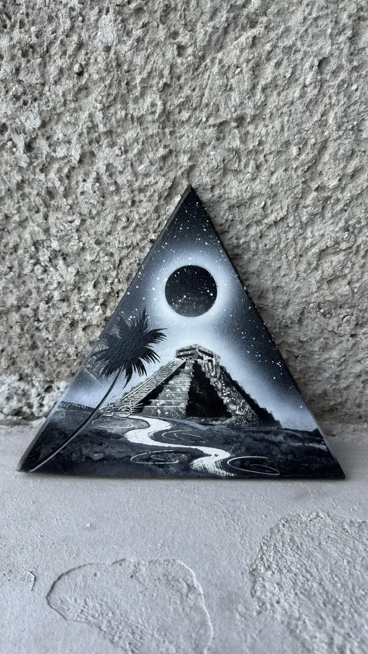 Black and white triangle painting of a Maya pyramid under an eclipse