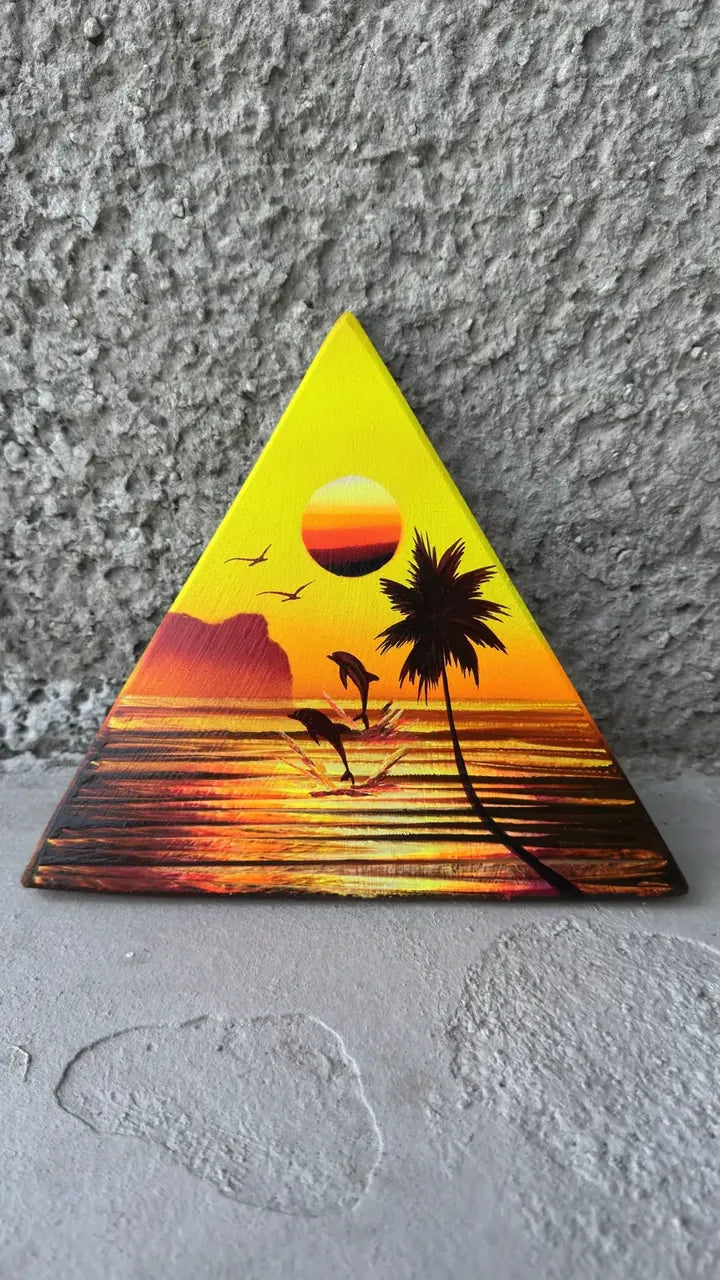 Yellow and orange triangle painting of a sunset with a palm tree and jumping dolphins